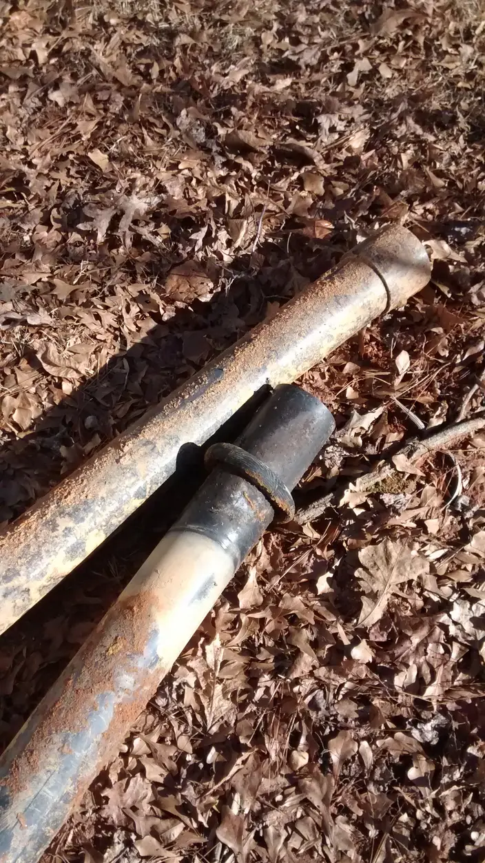 An excavated pipe repair with the damaged section exposed in the ground